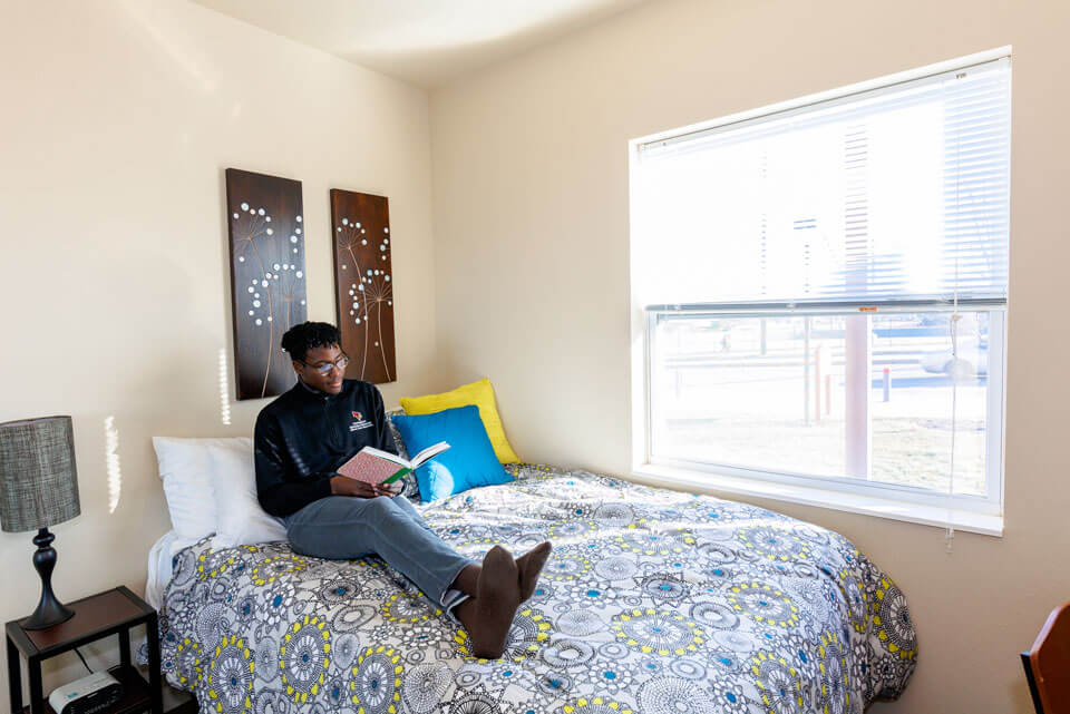 A student reads a book in his dorm.